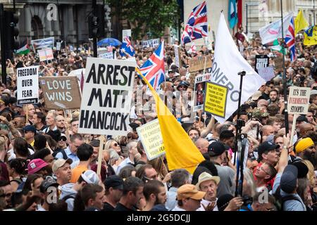 Londra, Regno Unito. 26 Giugno 2021. Manifestanti con cartelli marciano lungo Whitehall passando Downing Street. Migliaia di persone hanno marciato per sollevare le loro preoccupazioni riguardo alla legislazione governativa incentrata sulle vaccinazioni e sulla libertà di viaggiare. Credit: Andy Barton/Alamy Live News Foto Stock