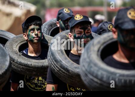 Gaza, Palestina. 26 Giugno 2021. I giovani palestinesi frequentano il campo estivo militare organizzato dal movimento islamico Jihad. I campi estivi militari a Gaza hanno cominciato oggi ad addestrare i giovani a difendersi e anche la loro patria, come un messaggio di forza per Israele per preparare una forte generazione palestinese che possa in futuro liberare Gerusalemme e i territori palestinesi. Credit: SOPA Images Limited/Alamy Live News Foto Stock