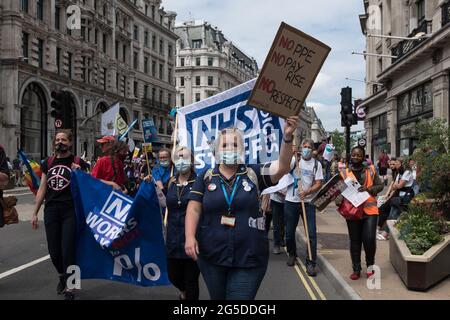 Londra, Regno Unito. 26 Giugno 2021. Il personale dell'NHS attraversa il centro di Londra durante l'Assemblea popolare contro la dimostrazione nazionale dell'austerità. I manifestanti di varie organizzazioni protestano contro la gestione da parte del governo della pandemia del coronavirus e chiedono la rinazionalizzazione delle industrie chiave, la lotta al razzismo istituzionale e l'azione sull'emergenza climatica. Credit: Wiktor Szymanowicz/Alamy Live News Foto Stock
