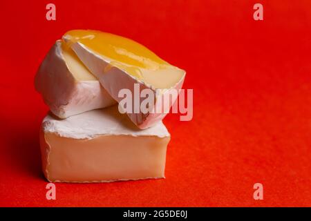 formaggio con muffa bianca e miele su fondo rosso Foto Stock