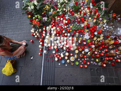 26 giugno 2021, Baviera, Würzburg: Una giovane donna accende una candela di fronte a un grande magazzino chiuso e cordonato nel centro della città. A Würzburg, un uomo attaccò casualmente le persone con un coltello. Secondo la Deutsche Presse-Agentur, tre persone sono state uccise e cinque ferite. Foto: Karl-Josef Hildenbrand/dpa Foto Stock