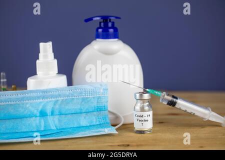 Maschera medica viso, vaccino, alcol gel disinfettante mani - igiene personale, covid-19, concetto di protezione coronavirus Foto Stock