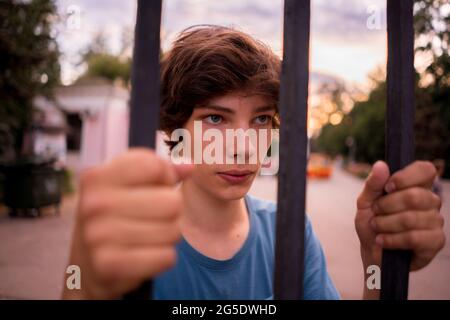 Close up dispair uomo in piedi accanto alla cella guardando la città libertà vita Foto Stock
