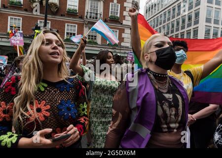 Londra, Regno Unito. 26 Giugno 2021. L'attivista del modello e dell'LGBT Munroe Bergdorf (C) si unisce alle persone transgender e ai loro sostenitori mentre attraversano il centro di Londra durante la terza marcia di protesta del Trans Pride per l'uguaglianza. I manifestanti chiedono investimenti in assistenza sanitaria trans, bagni accessibili e strutture carcerarie, la fine di interventi chirurgici non consensuali sui bambini intersessuali e il divieto di terapie di conversione pseudoscientifiche. Credit: Wiktor Szymanowicz/Alamy Live News Foto Stock