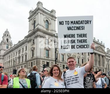 Londra, Regno Unito. 26 Giugno 2021. Un protestore anti-blocco che solleva un cartello che dice 'no ai vaccini obbligatori! dove c'è rischio, deve esserci scelta!" Fuori Westminster, durante la dimostrazione. I raduni anti-blocco si svolsero lungo Westminster, attraverso Downing Street fino a Trafalgar Square. I combattenti per la libertà sono scesi in piazza dopo l'appello di United for Freedom, chiedendo la rimozione delle restrizioni COVID 19 come l'uso di maschere, la vaccinazione e il blocco, in quanto queste impongono una violazione dei diritti umani. Credit: SOPA Images Limited/Alamy Live News Foto Stock