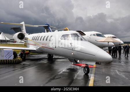 Bombardier Learjet 45XR e altri jet commerciali sotto nuvole oscure alla fiera di Farnborough International Airshow 2012, Regno Unito. Piani executive Foto Stock