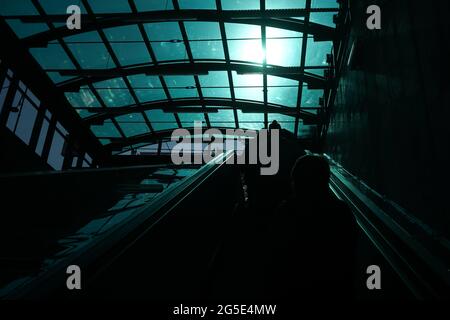 Bucarest, Romania - 22 giugno 2021: Il riflesso della luce che passa attraverso il soffitto smaltato risplende in forte contrasto con la scala mobile della e Foto Stock