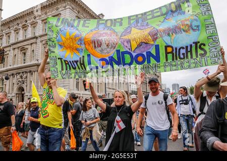 Londra, Regno Unito. 26 Giugno 2021. Londra, Regno Unito il 26 giugno 2021: I manifestanti che tengono i cartelli marciano verso il basso Whitehall durante la dimostrazione Anti-Lockdown Unite per la libertà. Le persone che protestavano contro i blocchi si sono riunite per sollevare le loro preoccupazioni in merito alle leggi governative sulle vaccinazioni e alla libertà di viaggiare e socializzare. (Foto di Dominika Zarzycka/Sipa USA) Credit: Sipa USA/Alamy Live News Foto Stock