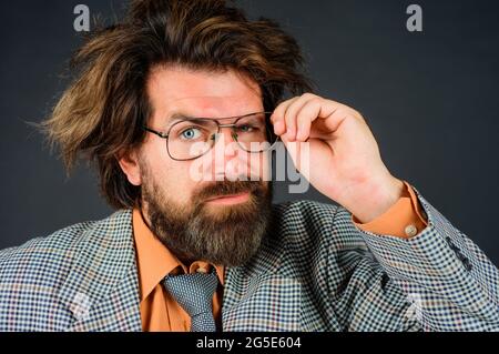 Insegnante confuso o uomo d'affari. Concetto di scuola, istruzione e business. Uomo d'affari bearded in vestito. Foto Stock