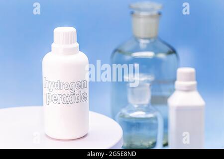 contenitore di plastica, flacone di medicina, scritto in inglese: perossido di idrogeno, fondo blu isolato, concetto di prima cura Foto Stock