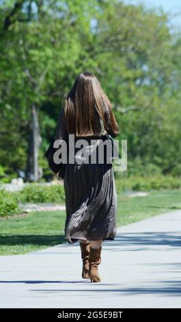 una donna non riconosciuta che cammina attraverso il parco Foto Stock