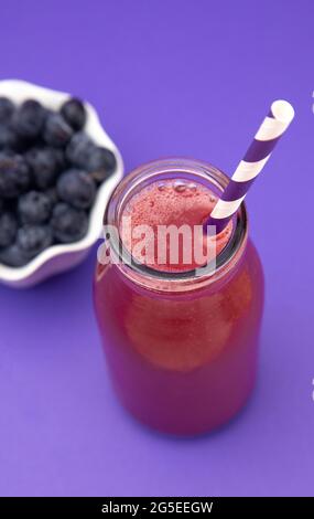 Berry Smoothie in una caraffa di vetro con una paglia Foto Stock