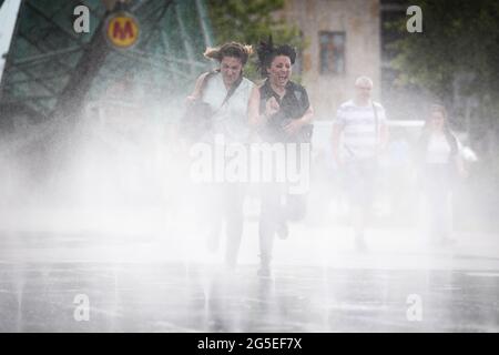 Varsavia, Polonia. 26 Giugno 2021. Le donne corrono in un paraspruzzi durante una giornata calda a Varsavia, Polonia, il 26 giugno 2021. Credit: Jaap Arriens/Xinhua/Alamy Live News Foto Stock