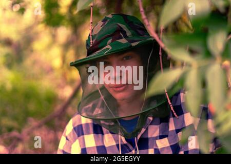 un uomo viaggiatore nella maschera di zanzara per proteggere il viso dagli insetti Foto Stock