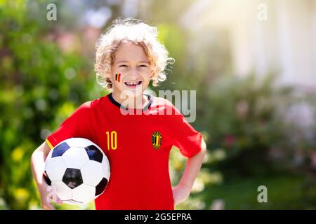 Tifoso di calcio belga. I bambini belgi giocano a calcio sul campo all'aperto. I tifosi del team festeggiano la vittoria. Vai diavoli rossi! I bambini segnano un gol al calcio Foto Stock