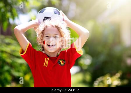 Tifoso di calcio belga. I bambini belgi giocano a calcio sul campo all'aperto. I tifosi del team festeggiano la vittoria. Vai diavoli rossi! I bambini segnano un gol al calcio Foto Stock