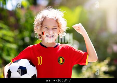 Tifoso di calcio belga. I bambini belgi giocano a calcio sul campo all'aperto. I tifosi del team festeggiano la vittoria. Vai diavoli rossi! I bambini segnano un gol al calcio Foto Stock