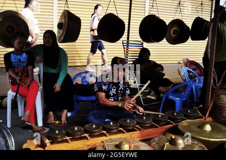 Malay suonando gongs tradizionale strumento di musica malese stile per mostrare e vendere persone viaggiatore sul pavimento di strada negozio al mercato filippino Kota Kinab Foto Stock