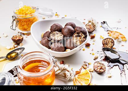 Primo piano caramella fatta a mano con miele, uvetta, frutta d'arancia candita e arachidi al cioccolato. Dolci a base di ingredienti biologici naturali Foto Stock