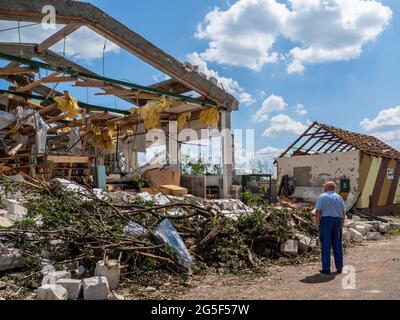 Hodonin, Repubblica Ceca. 26 Giugno 2021. Un uomo visto guardando l'ex edificio scolastico, distrutto da un tornado.Tornado in Repubblica Ceca, nella regione della Moravia del Sud. Tornado della forza 4F distrusse diversi villaggi giovedì 24 giugno, intorno alle 20:00. Dopo un minuto di attività ha lasciato 5 morti e 200 feriti e ha danneggiato centinaia di case. Questa regione si trova ad affrontare per la prima volta un disastro di questo tipo. Gli scienziati avvertono che con i cambiamenti climatici, il tempo estremo si verificherà più spesso. Credit: SOPA Images Limited/Alamy Live News Foto Stock