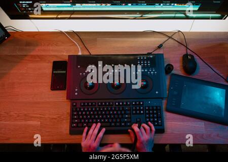 Male Video Editor Hands lavora con filmati o video sul suo pannello di controllo del Personal computer, lavora in Creative Office Studio o a casa. Luci al neon Foto Stock
