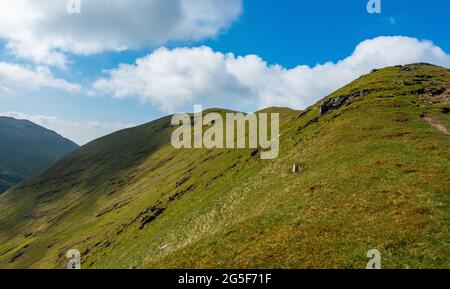 Guardando indietro lungo il crinale da Meall a Choire Leith alla montagna munro di Meall Corranaich, parte della catena ben Lawers in Scozia Foto Stock