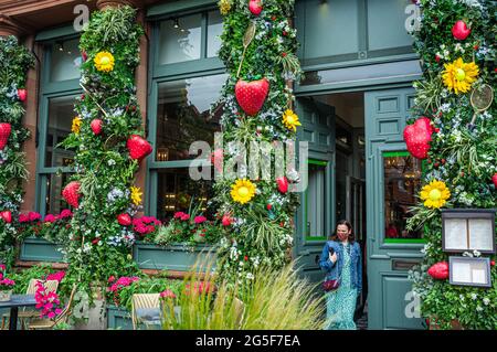 Wimbledon, Londra, Regno Unito. 27 giugno 2021. La caffetteria Ivy nel Villaggio di Wimbledon e' decorata con temi di tennis alla vigilia dei campionati di Wimbledon che iniziano lunedì 28 giugno 2021. Il torneo dell'anno scorso è stato annullato a causa della pandemia del Covid-19 per la prima volta dalla seconda guerra mondiale e si svolgerà dal 28 giugno al 11 luglio con una capacità ridotta del 50% e saranno ammessi solo gli spettatori con biglietti preordinati e non sarà consentito fare la coda o il campeggio. Credit: amer Ghazzal/Alamy Live News Foto Stock