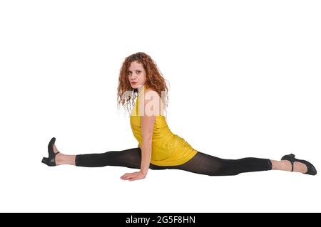 Concetto di flessibilità modello femminile con capelli rossi che si estende su sfondo bianco Foto Stock