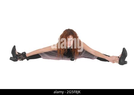 Concetto di flessibilità modello femminile con capelli rossi che si estende su sfondo bianco Foto Stock