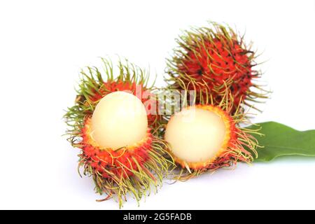 Rambutan dolce, frutta popolare in Thailandia isolato su sfondo bianco. Sbucciare la pelle per rivelare i semi all'interno. Con le foglie Foto Stock