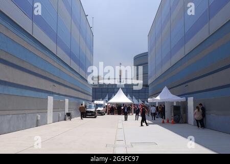 Lungo pavimento in cemento che cammina tra due grandi edifici in una giornata di sole Foto Stock