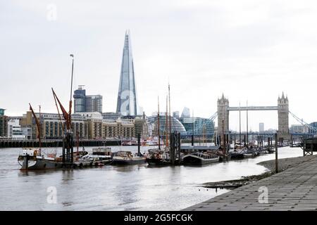 Vista delle barche nel molo vicino al Tower Bridge e il grattacielo Shard attraverso il Tamigi nella primavera del 2021 Londra Inghilterra Regno Unito KATHY DEWITT Foto Stock