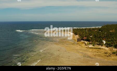 Surf spot con i surfisti sulle onde al tramonto sull'isola di Siargao, nuvola 9, Filippine. Vista aerea. Foto Stock