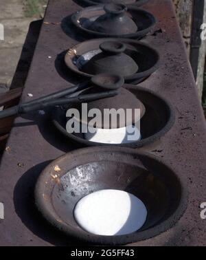 Primo piano di serabi o frittelle cucinate a mano della madre in una padella fatta di terreno. Foto Stock