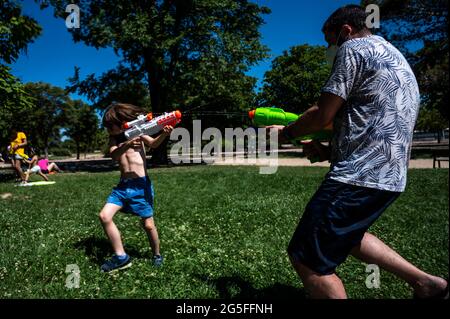 Madrid, Spagna. 27 Giugno 2021. Le persone che giocano con le armi d'acqua che prendono parte a una lotta estiva sull'acqua nel quartiere di Vicalvaro a Madrid. Credit: Marcos del Mazo/Alamy Live News Foto Stock