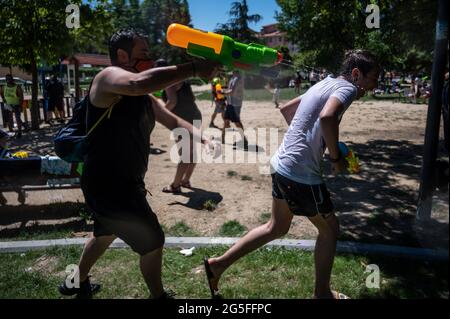 Madrid, Spagna. 27 Giugno 2021. Le persone che giocano con le armi d'acqua che prendono parte a una lotta estiva sull'acqua nel quartiere di Vicalvaro a Madrid. Credit: Marcos del Mazo/Alamy Live News Foto Stock