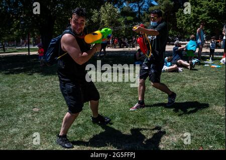 Madrid, Spagna. 27 Giugno 2021. Le persone che giocano con le armi d'acqua che prendono parte a una lotta estiva sull'acqua nel quartiere di Vicalvaro a Madrid. Credit: Marcos del Mazo/Alamy Live News Foto Stock