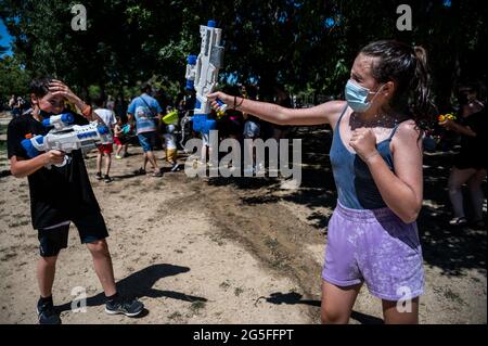 Madrid, Spagna. 27 Giugno 2021. Le persone che giocano con le armi d'acqua che prendono parte a una lotta estiva sull'acqua nel quartiere di Vicalvaro a Madrid. Credit: Marcos del Mazo/Alamy Live News Foto Stock