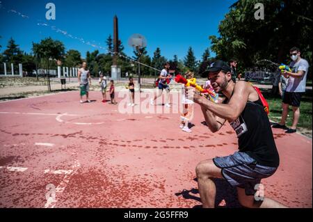 Madrid, Spagna. 27 Giugno 2021. Le persone che giocano con le armi d'acqua che prendono parte a una lotta estiva sull'acqua nel quartiere di Vicalvaro a Madrid. Credit: Marcos del Mazo/Alamy Live News Foto Stock