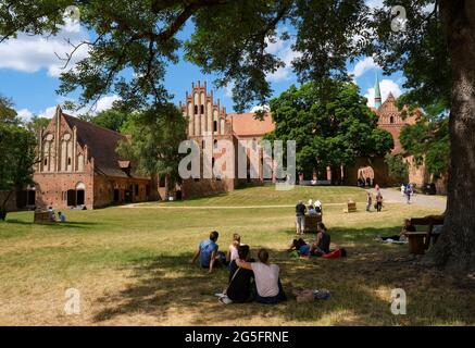 Chorin, Germania. 27 giugno 2021. I visitatori siedono di fronte al monastero di Chorin alla 58a Estate musicale di Chorin con un concerto della Mendelssohn Chamber Orchestra Leipzig. A causa della pandemia di Corona, quest'anno i visitatori possono sedersi solo su sedie per mantenere la distanza minima. Sono disponibili solo 500 posti su 1200. Il primo concerto si è svolto il 23 maggio 1964 come evento culturale dell'Istituto di Scienze della Foresta di Eberswalde.000 gue Credit: dpa Picture Alliance/Alamy Live News Foto Stock