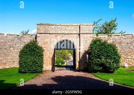 Castlegate visto attraverso la cima piatta, arco, cancello d'ingresso principale per Jedburgh Gaol con il suo sham portcullis e yett impostato in pareti battagliate Foto Stock