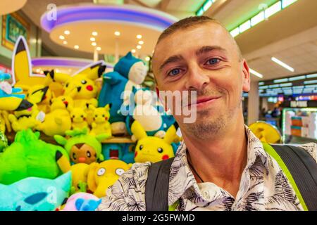 Turistico con colorati Pokemon Pikachu peluche giocattoli in Bangkok aeroporto Thailandia. Foto Stock