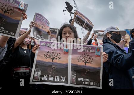 Londra, Regno Unito. 27 Giugno 2021. Apple Daily protesta a Piccadilly Circus. I giornalisti e i sostenitori del più grande negozio di notizie pro-democrazia di Hong Kong tengono copie cartacee del Regno Unito per protestare contro la chiusura forzata e il congelamento dei beni del tabloid di 26 anni. L'ultima edizione di Apple Daily è stata pubblicata il giovedì 24 con le autorità di Hong Kong che arrestano cinque redattori e dirigenti. Credit: Guy Corbishley/Alamy Live News Foto Stock