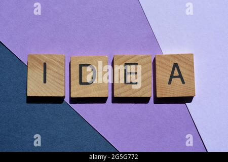 Idea, parola in lettere alfabetiche in legno isolato su sfondo viola e blu come titolo banner Foto Stock
