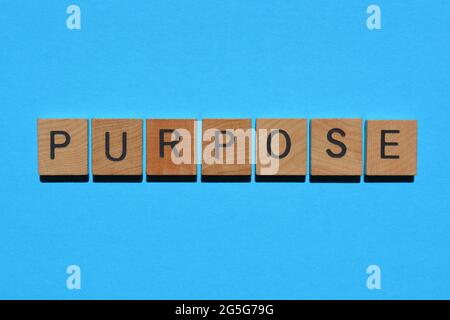 Scopo, parola in lettere alfabetiche in legno isolate su sfondo blu luminoso Foto Stock