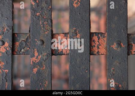 arrugginito, sbucciando la vernice su barrette metalliche incrociate con viti fanno un fondo grintoso, urbano texture in marrone profondo, arancio, umber bruciato, terra di terracotta Foto Stock