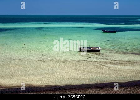 Splendida vista sulla costa mediterranea con acqua di betulla, spiaggia di sabbia bianca e barca da pesca Foto Stock