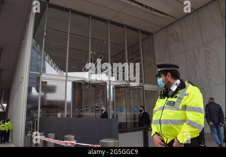 Londra, Regno Unito. 27 giugno 2021. Un poliziotto si trova al di fuori di News UK durante la protesta della Free The Press. Estinzione i manifestanti della ribellione marciarono da Parliament Square alla sede centrale di News UK, di proprietà di Rupert Murdoch, a London Bridge, per protestare contro disinformazione, corruzione, e contro l'imprecisa e insufficiente copertura della crisi climatica da parte dei giornali di Murdoch. (Credit: Vuk Valcic / Alamy Live News) Foto Stock