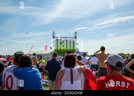 Inghilterra / Germania Coppa del mondo 2010 sul grande schermo durante la battaglia di Gran Bretagna airshow dogfight. Data scontro con grande gioco di calcio in modo partita giocato alla folla Foto Stock