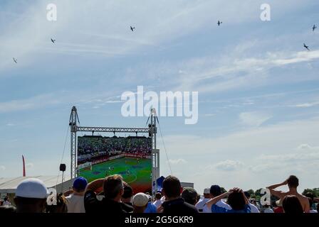 Inghilterra / Germania Coppa del mondo 2010 sul grande schermo durante la battaglia di Gran Bretagna airshow dogfight. Data scontro con grande gioco di calcio in modo partita giocato alla folla Foto Stock